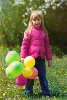 Outdoor portrait of a cute young  little girl playing with balloons