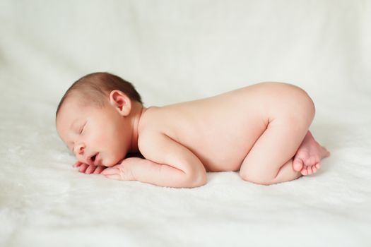 a beautiful sweet newborn baby sleeping on a blanket