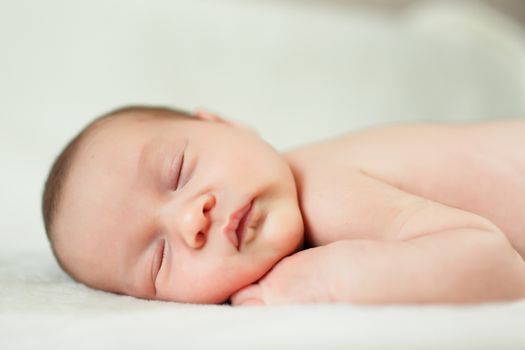 a beautiful sweet newborn baby sleeping on a blanket