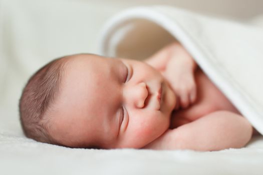 a beautiful sweet newborn baby sleeping on a blanket