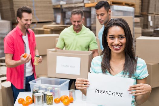 Warehouse workers packing up donation boxes in a large warehouse