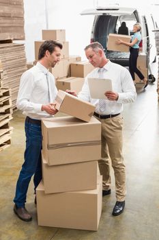 Warehouse managers checking their list in a large warehouse