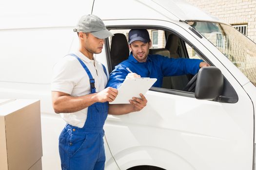 Delivery driver showing customer where to sign outside the warehouse