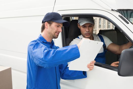 Delivery driver showing customer where to sign outside the warehouse