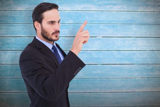 Focused businessman pointing in suit jacket against wooden planks