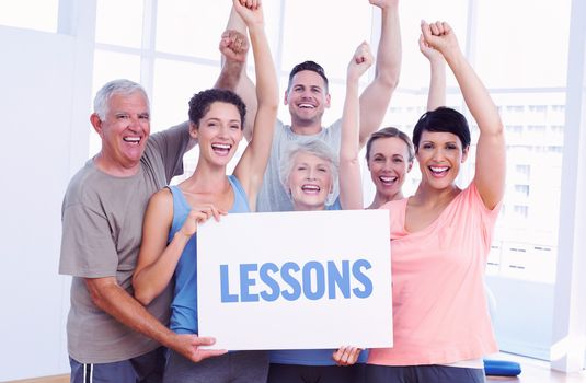 The word lessons against portrait of happy fit people holding blank board