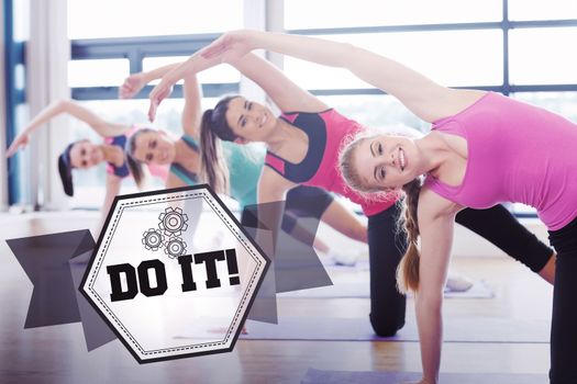 The word do it! and women stretching on mats at yoga class against hexagon