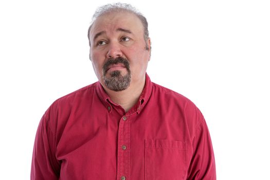 Middle-aged man with baldness and goatee beard wearing a dark red shirt while looking up to the left with a sad and depressed facial expression, isolated portrait on white