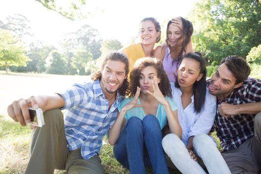 Smiling friends in the park taking selfie on a sunny day