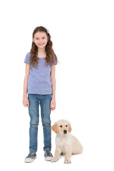 Smiling little girl standing next to dog on white background 