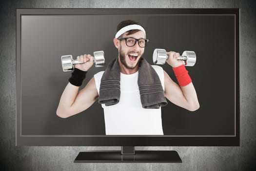 Geeky hipster lifting dumbbells in sportswear against blue background with vignette