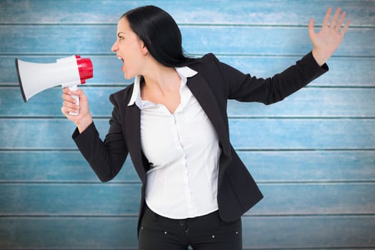 Pretty businesswoman shouting with megaphone against wooden planks