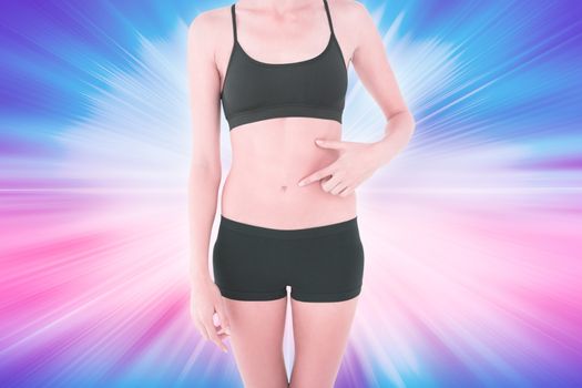 Closeup mid section of a fit woman with hand on stomach against abstract background