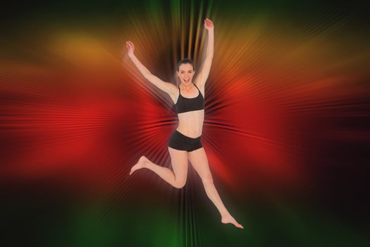 Full length of a sporty young woman jumping against abstract background