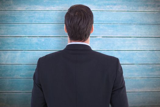 Rear view of handsome businessman  against wooden planks