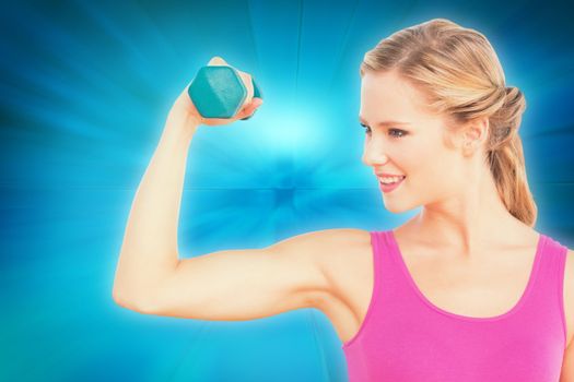 Fit blonde lifting dumbbell and flexing against abstract background