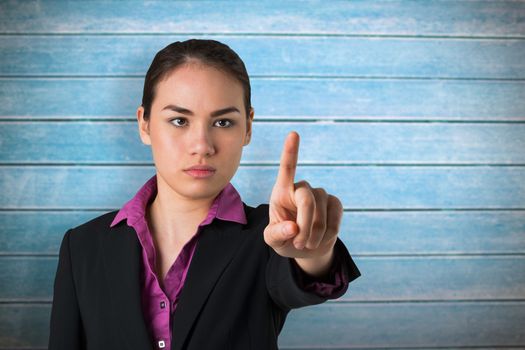 Serious businesswoman pointing against wooden planks