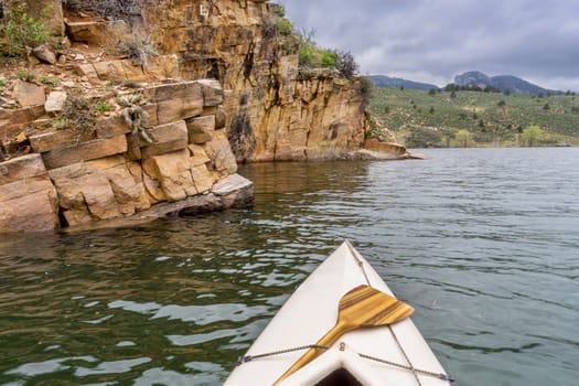 canoe and sandstone cliff - springtime paddling Horsetooth Reservoir near Fort Collins, Colorado