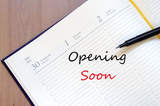 Yellow blank notepad on office wooden table Opening Soon Concept