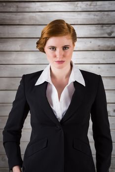 Stylish redhead businesswoman in suit against wooden planks