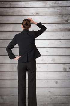 Businesswoman standing and thinking against wooden planks