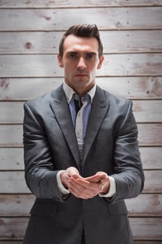 Businessman presenting with hands against wooden planks