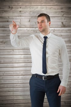 Young serious businessman pointing  against wooden planks background