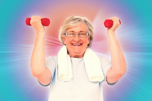 Senior woman lifting hand weights against abstract background