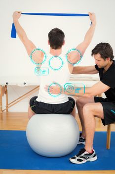 Man on yoga ball working with a physical therapist against fitness interface