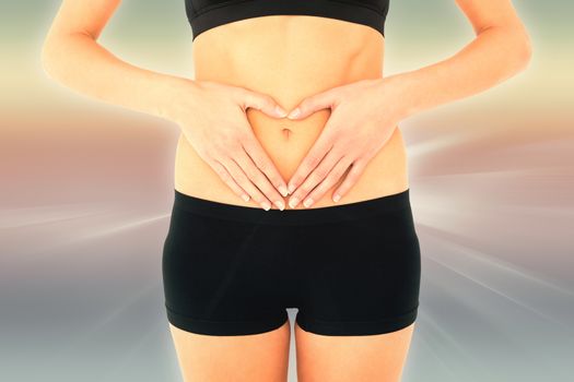 Closeup mid section of a fit woman in black shorts against abstract background