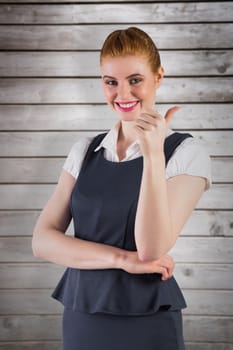 Redhead businesswoman showing thumbs up against wooden planks
