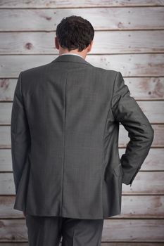 Businessman with hand on hip against wooden planks