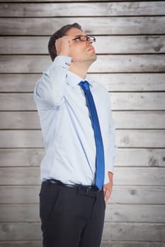 Thinking businessman tilting glasses against wooden planks