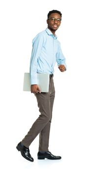 Happy african american college student with laptop standing on white background