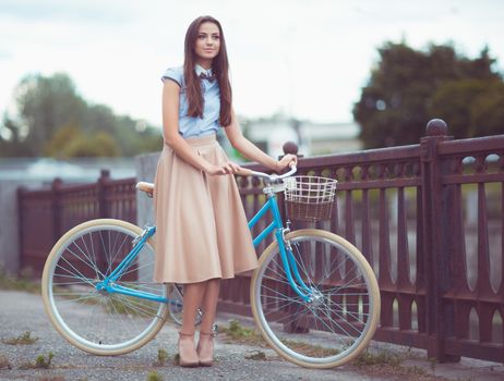 Young beautiful, elegantly dressed woman with bicycle. Beauty, fashion and lifestyle