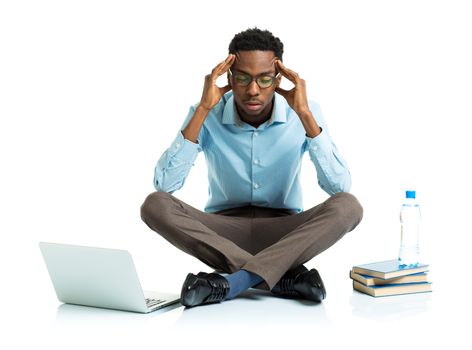 African american college student in stress sitting with laptop, books and bottle of water on white background