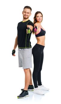 Athletic man and woman after fitness exercise with thumbs up on the white background