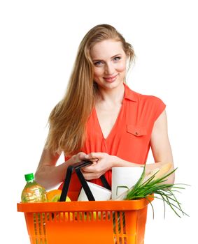 Happy young woman holding a basket full of healthy food on white background. Shopping