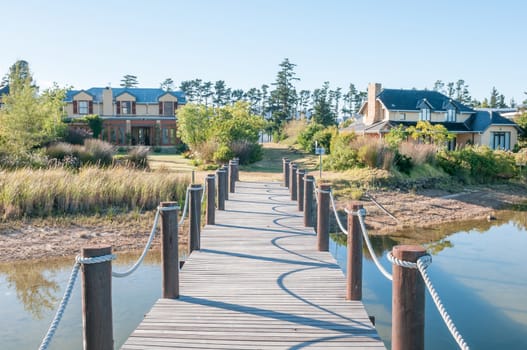 CAPE TOWN, SOUTH AFRICA - DECEMBER 18, 2014: Houses next to a dam with jetty on the Wedderville Estate near Sir Lowrys Pass
