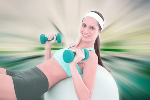 Smiling fit woman exercising with dumbbells on fitness ball against abstract background