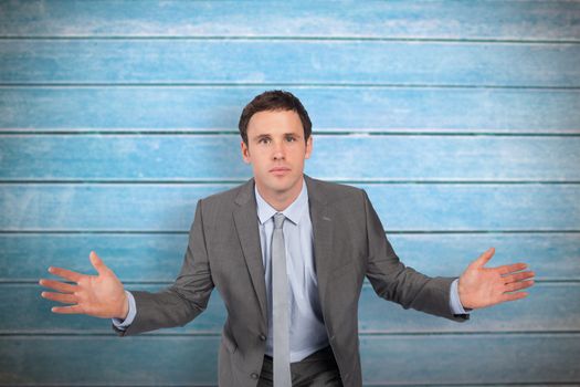 Businessman posing with hands out against wooden planks