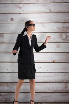 Blindfolded businesswoman with hands out against wooden planks