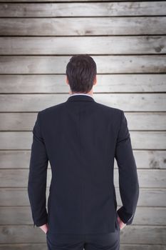Rear view of handsome businessman  against wooden planks