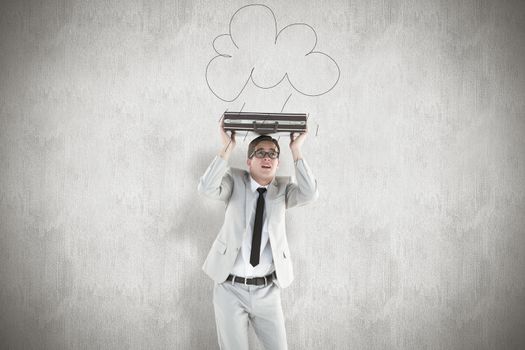 Handsome businessman sheltering with briefcase against white background