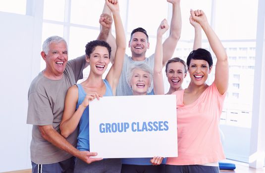 The word group classes against portrait of happy fit people holding blank board