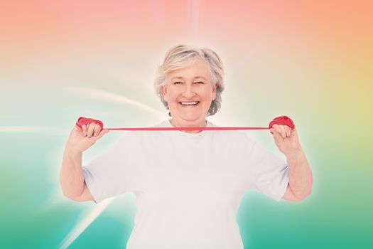 Senior woman using resistance band against abstract background