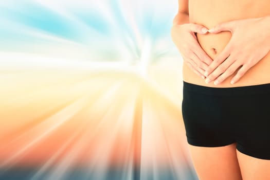 Closeup mid section of a fit woman in black shorts against abstract background