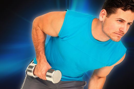 Fit young man exercising with dumbbell against abstract background