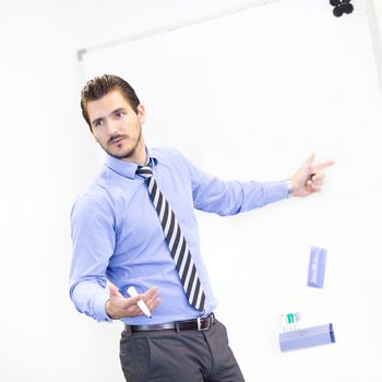 Business man making a presentation in front of whiteboard. Copy space.