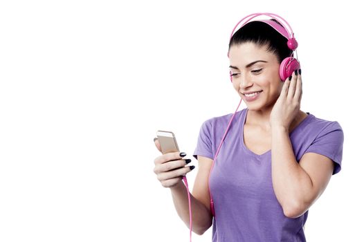 Happy woman listening music from her cell phone